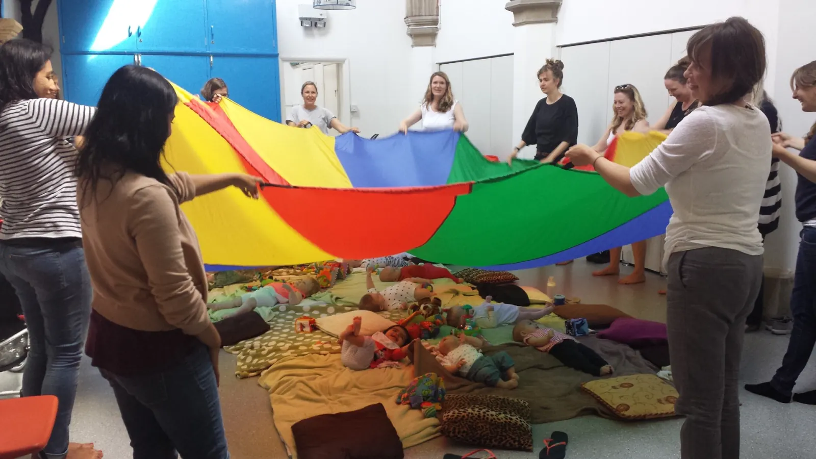 Parents and babies taking part in a colourful parachute activity